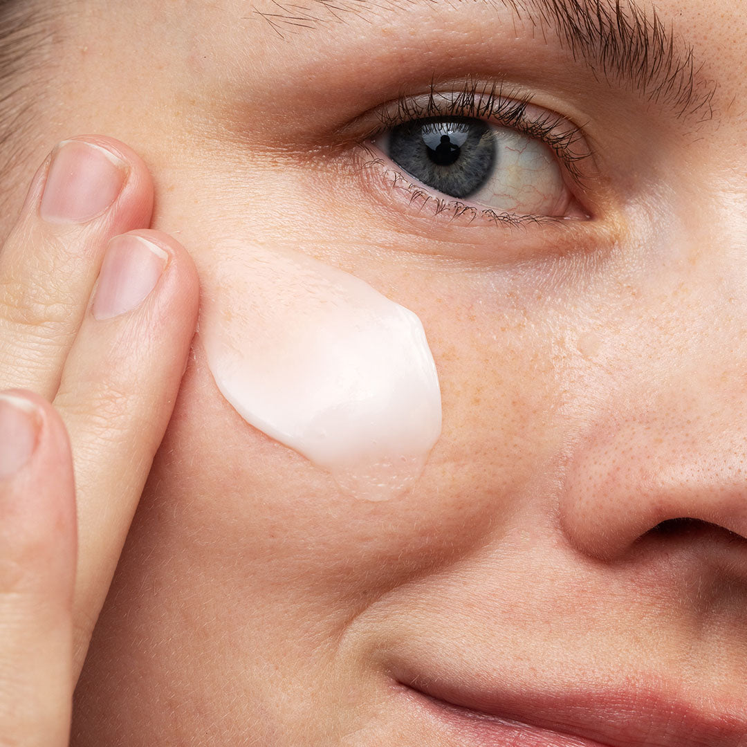 A person applies HydraDew Moisturizer gel to their cheek, with a close-up on their face and eye.