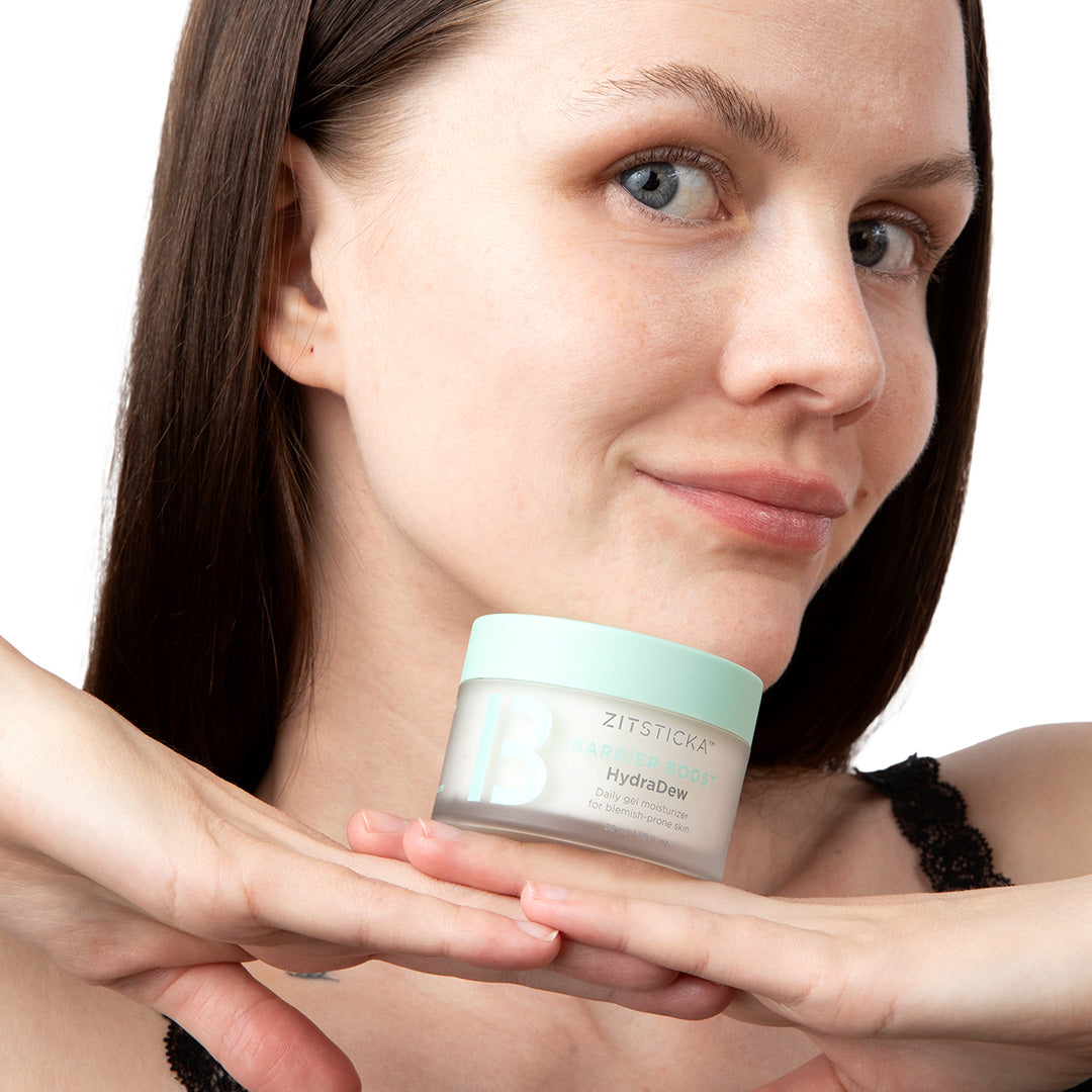 Woman smiling and holding HydraDew Moisturizer & BFF Hydrating Serum with niacinamide under her chin.