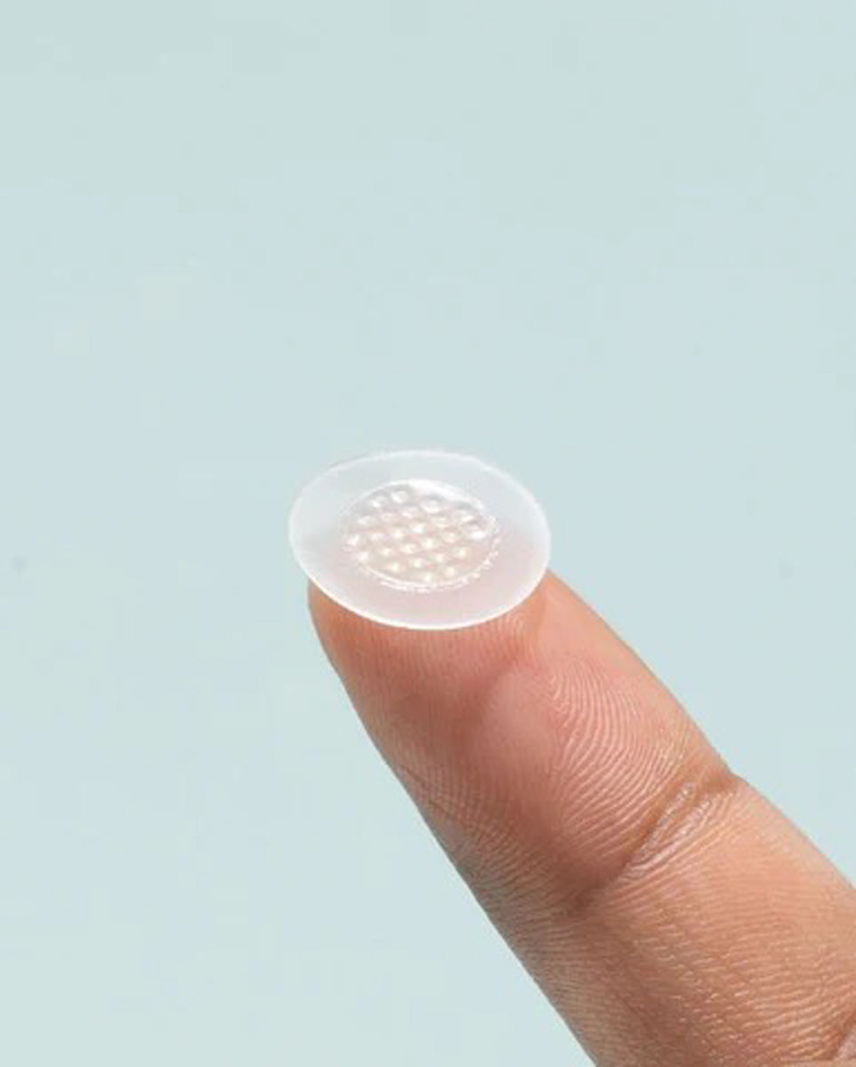 A Free Gift: Best Seller Killa Sample patch with raised dots is balanced on a fingertip.